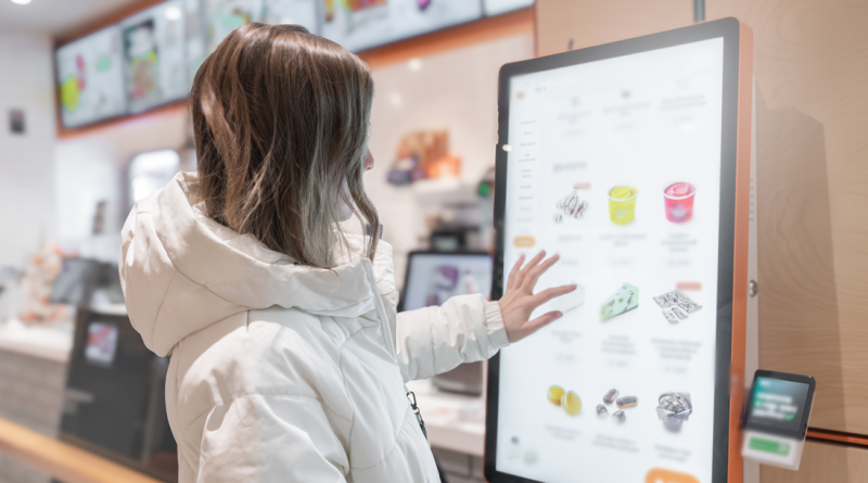 Customer using a fast food paying machine to order food