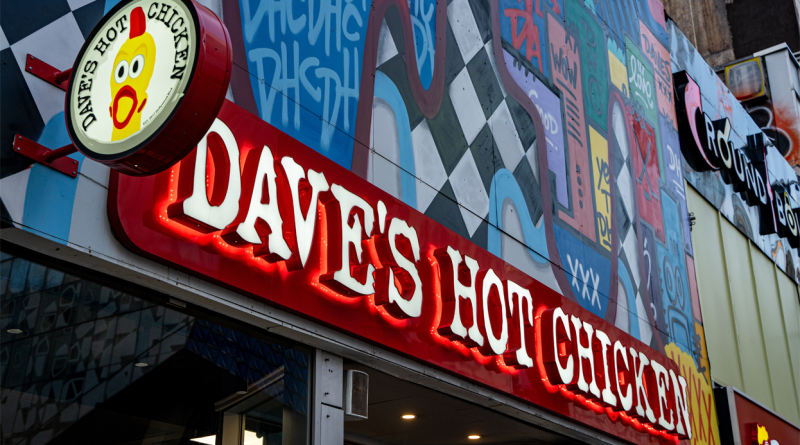 Dave’s Hot Chicken restaurant storefront showing colourful red, white and yellow brand name and logo