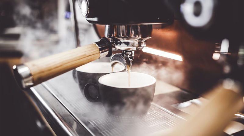 Coffee machine steaming milk and pouring coffee shots into mugs to support Local 4 cafe article