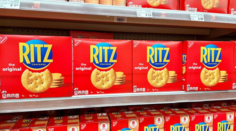 Boxes of Ritz Original Crackers and Ritz Fresh Stacks neatly arranged on supermarket shelves, with visible price tags and bright red packaging.