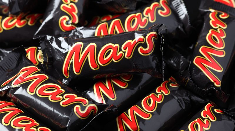 Exterior view of a Mars Wrigley U.S. manufacturing facility with Snickers branding on display.