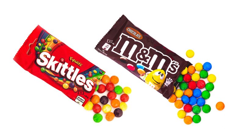 A bag of Skittles and a bag of chocolate M&M's to support Mars natural colors strategy article