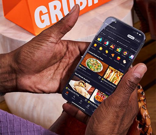 College student asleep on couch as food delivery arrives, with phone showing Grubhub notification