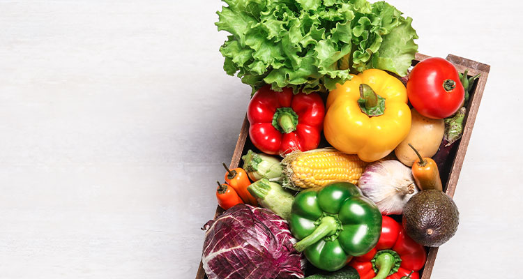 a variety of fresh fruits and vegetables in a wooden crate