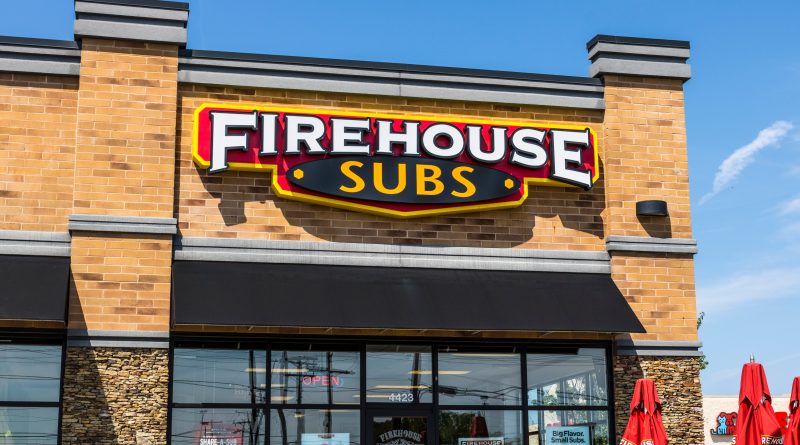 A branded Firehouse Subs Gravy Extinguisher on a Thanksgiving table with turkey in the background