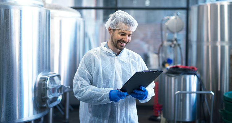 food production engineer or technician checking a process in a food or beverage manufacturing facility.