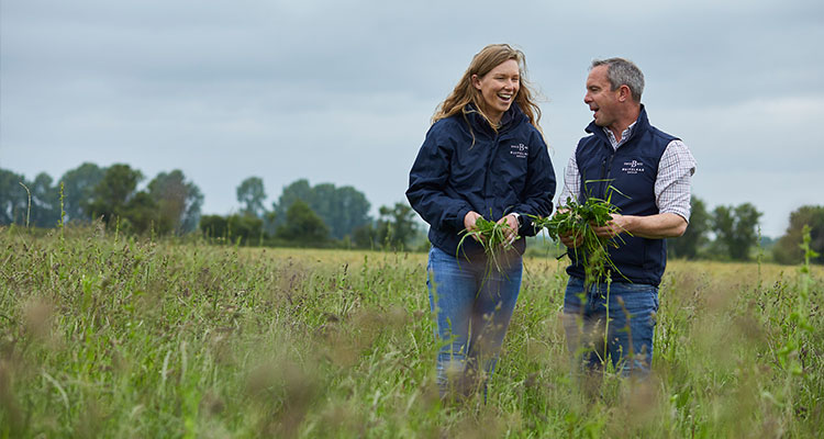 a man and a woman, standing together in a field
