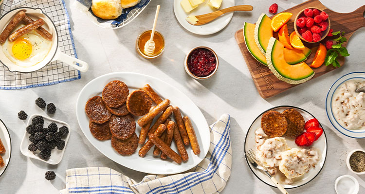 a hearty breakfast board spread featuring sausage links and patties along with side dishes